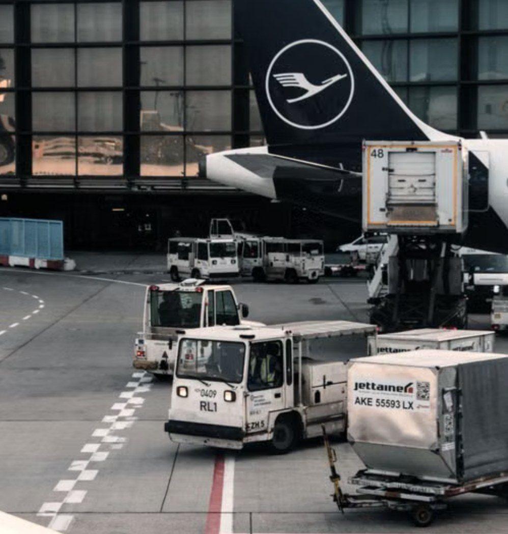 Tugs and dollies moving containers on an airport apron